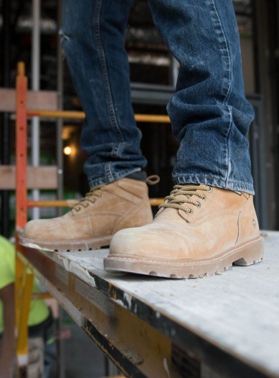 a person wearing brown boots and jeans